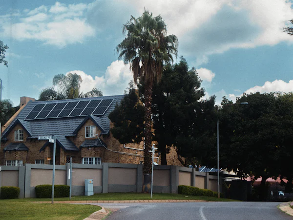 Tile-roof home with solar panels and palm trees