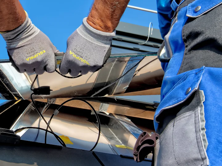 Gloved hands installing solar wiring